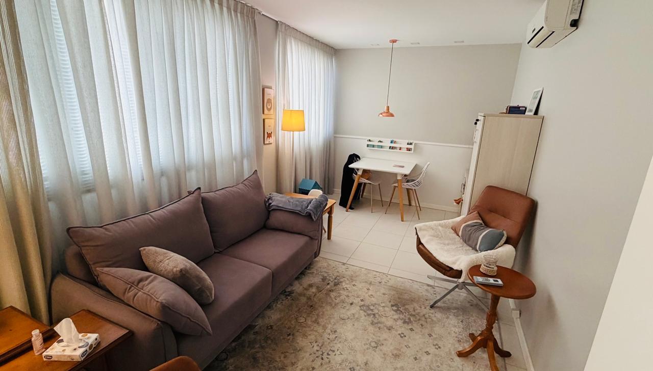 Interior do consultório no Ed. Albert Einstein, em Passo Fundo, com sofá, poltrona e iluminação natural.